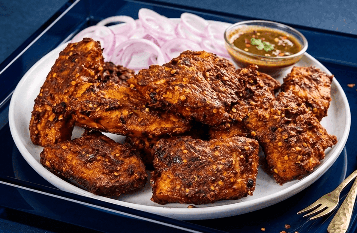 Lahori tawa fish fry with a crispy besan spice crust on a street-food paper wrap