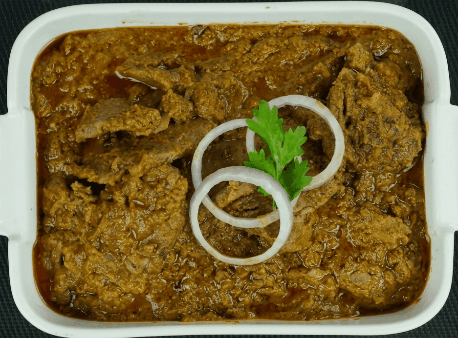 f Bihari Pasanday, a traditional South Asian meat dish, served in a white rectangular ceramic dish with small handles. The dish features thin, tenderized strips of meat slow-cooked in a thick, rich, and grainy dark brown masala gravy that shows signs of oil separation. The meat is garnished in the center with a few rings of raw red onion, and a single sprig of green coriander.